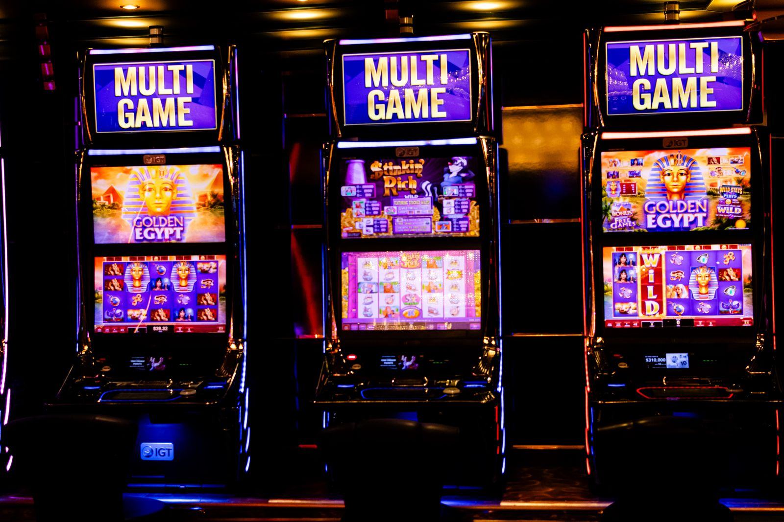 Deretan mesin slot bercahaya warna-warni di lantai kasino