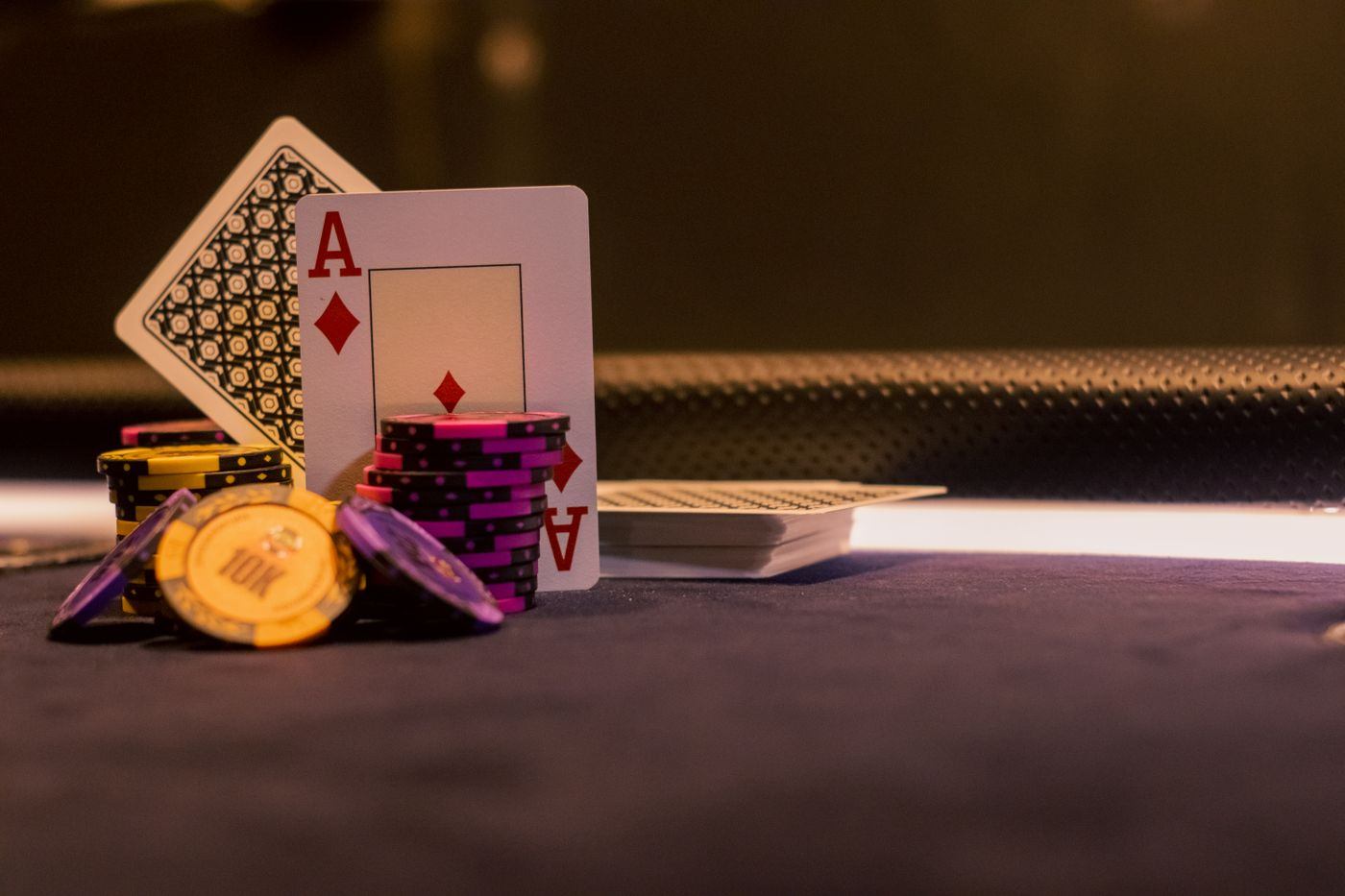 Kartu remi dan tumpukan chip poker di atas meja permainan